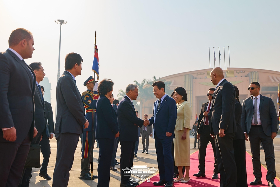 이집트 공식 방문 일정을 마친 이재명 대통령이 21일(현지시간) 카이로 국제공항에서 남아프리카공화국 요하네스버그로 출발하기 전 환송인사와 악수하고 있다. 