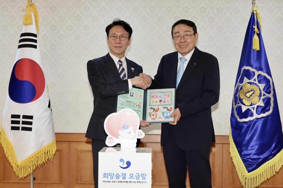 김민석 국무총리가 2일 세종대로 정부서울청사에서 열린 크리스마스 씰 증정식에서 신민석 대한결핵협회 회장으로부터 크리스마스 씰 액자를 전달받고 있다.