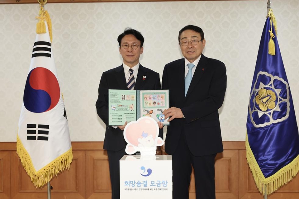 김민석 국무총리가 2일 세종대로 정부서울청사에서 열린 크리스마스 씰 증정식에서 신민석 대한결핵협회 회장으로부터 크리스마스 씰 액자를 전달받고 있다.