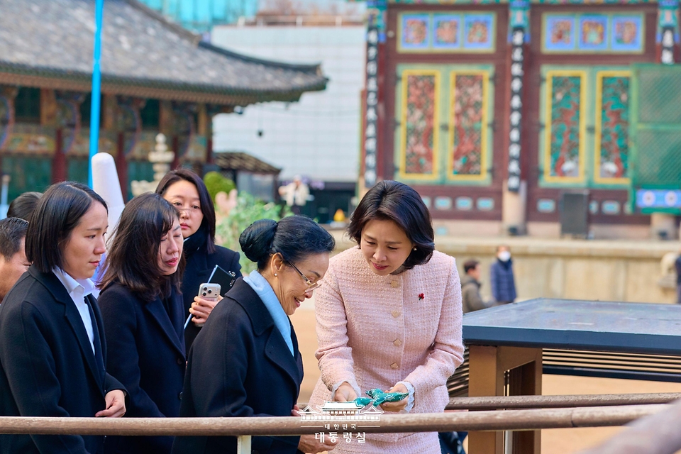 김혜경 여사가 14일 서울 종로구 조계사에서 라오스 국가주석 부인 날리 시술릿 여사와 함께 이동하며 핫팩을 건네고 있다.