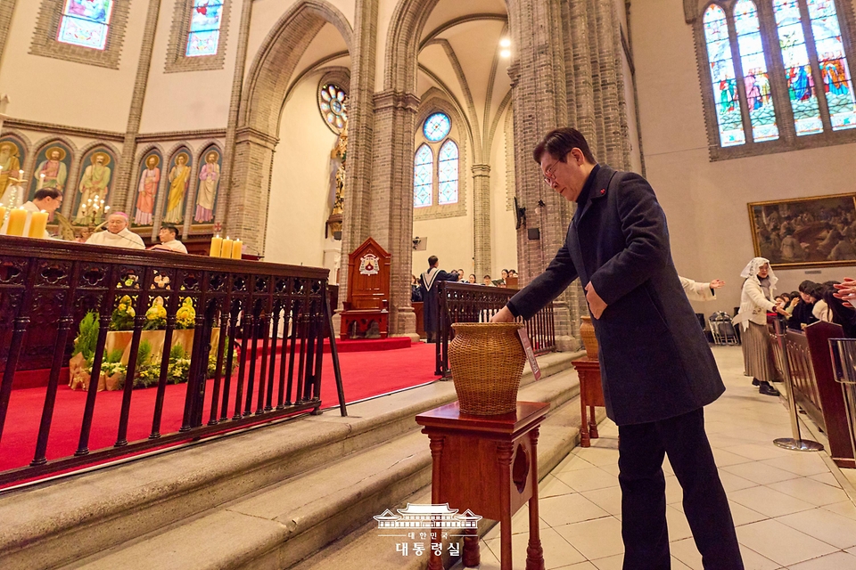 이재명 대통령이 25일 서울 중구 명동대성당에서 열린 성탄 대축일 미사에서 헌금을 하고 있다.