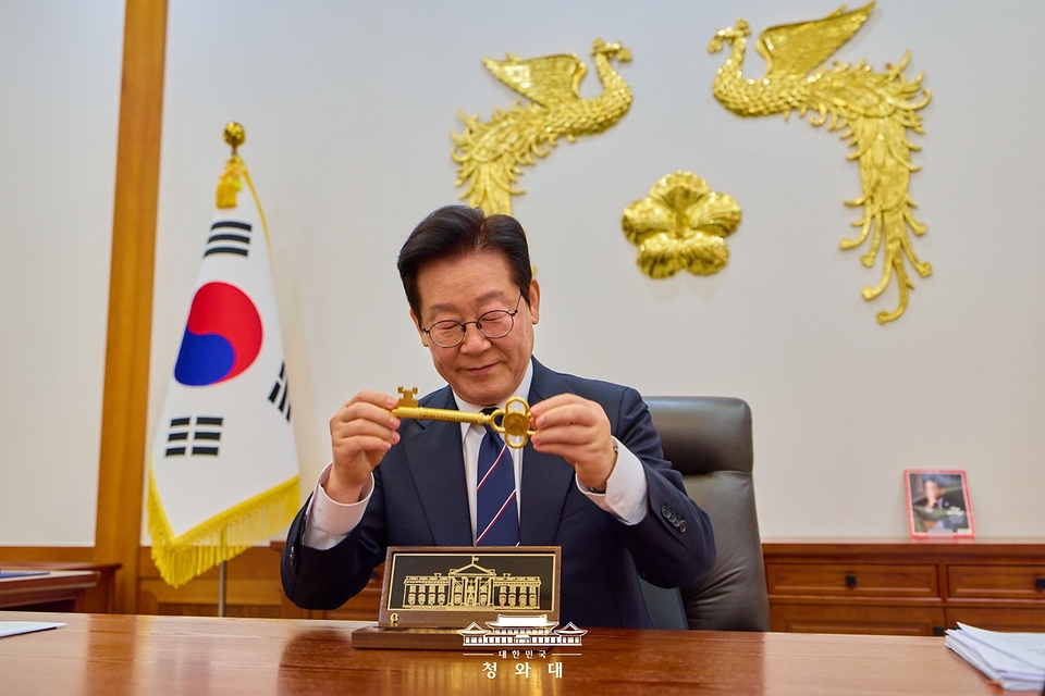 이재명 대통령이 30일 청와대 집무실에서 도널드 트럼프 미국 대통령이 선물한 '백악관 황금 열쇠'를 살펴보고 있다.
