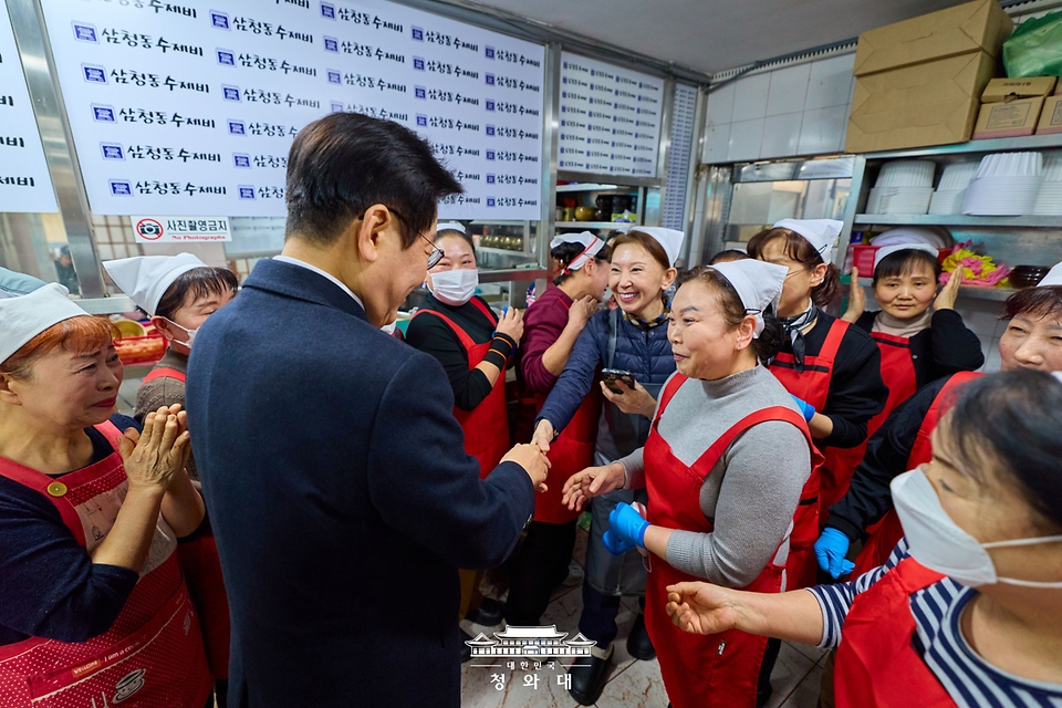 이재명 대통령이 30일 서울 종로구 삼청동의 한 음식점을 찾아 상인들과 인사를 하고 있다. 