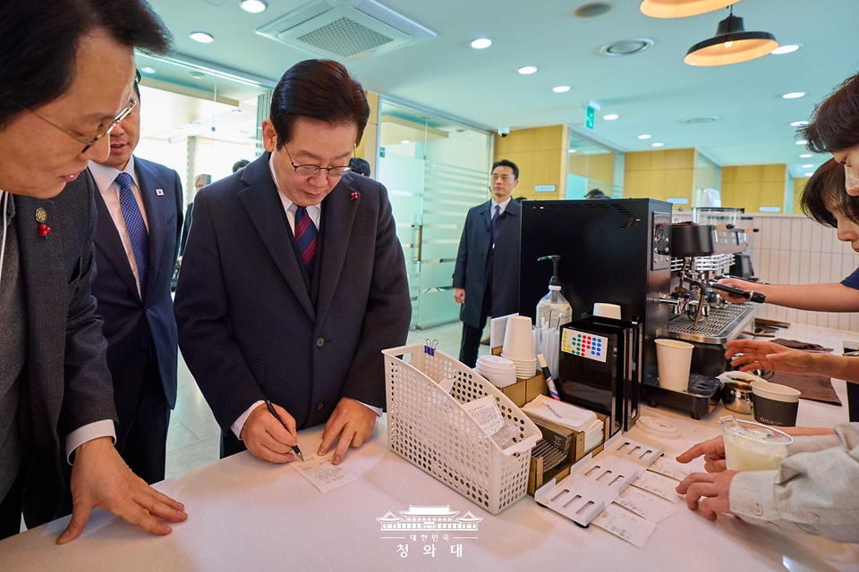 이재명 대통령이 1월 2일 새해를 맞아 청와대 연풍문 내 카페 '아이갓에브리띵'에 방문해 직원들이 주문하는 음료를 사전 계산하고 있다.