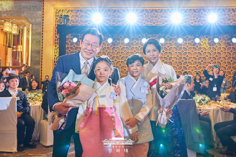 중국을 국빈 방문 중인 이재명 대통령과 김혜경 여사가 1월 4일 베이징 한 호텔에서 열린 재중 한국인 간담회에서 화동에게 꽃다발을 전달 받은 후 기념촬영을 하고 있다.