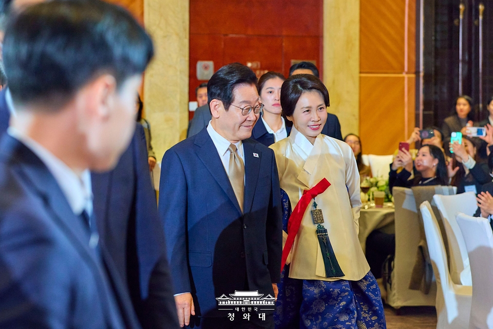 이재명 대통령과 김혜경 여사가 1월 4일 중국 베이징 한 호텔에서 열린 재중 한국인 간담회에 입장하고 있다.