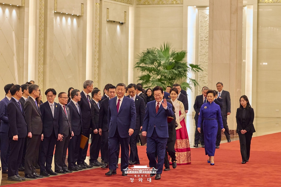중국을 국빈 방문 중인 이재명 대통령과 김혜경 여사가 1월 5일(현지 시간) 중국 베이징 인민대회당에서 열린 공식환영식에서 시진핑 국가주석, 부인 펑리위안 여사와 이동하며 환영 나온 어린이들에게 인사하고 있다.
