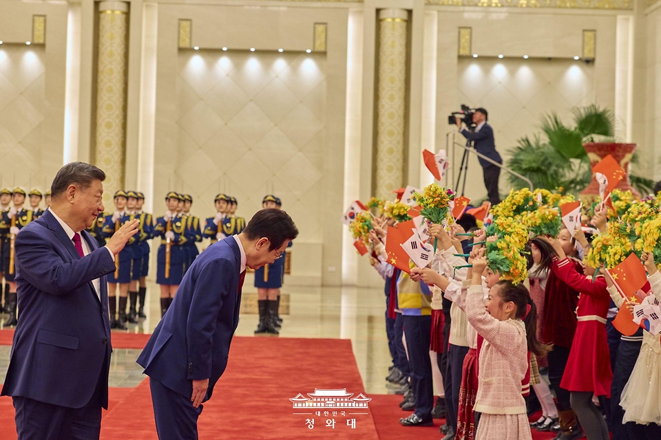 중국을 국빈 방문 중인 이재명 대통령이 1월 5일(현지 시간) 중국 베이징 인민대회당에서 열린 공식환영식에서 시진핑 국가주석과 이동하며 환영 나온 어린이들에게 인사하고 있다.