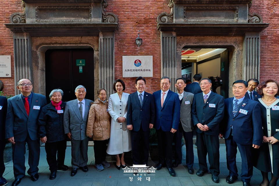 이재명 대통령과 김혜경 여사가 1월 7일(현지 시간) 중국 상하이 대한민국 임시정부 청사에서 열린 청사 건립 100주년 기념식을 마친 뒤 독립유공자 후손들과 기념촬영을 하고 있다.