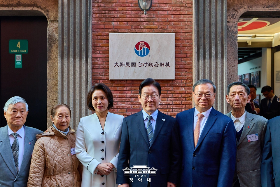 이재명 대통령과 김혜경 여사가 1월 7일(현지 시간) 중국 상하이 대한민국 임시정부 청사에서 열린 청사 건립 100주년 기념식을 마친 뒤 독립유공자 후손들과 기념촬영을 하고 있다.