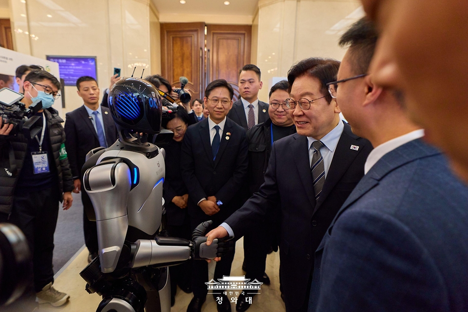 중국을 국빈 방문 중인 이재명 대통령이 1월 7일(현지 시간) 중국 상하이 상해국제회의중심에서 열린 한-중 벤처스타트업 서밋을 방문해 중국 기업 엣지봇의 휴머노이드 로봇과 악수를 하고 있다.