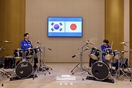 이재명 대통령과 다카이치 사나에 일본 총리가 1월 13일 일본 나라현에서 정상회담 후 환담장에서 드럼 합주를 하고 있다. 양 정상은 '케이팝 데몬 헌터스'의 주제가 '골든'과 BTS의 히트곡 '다이너마이트'에 맞춰 드럼을 함께 연주했다. 다카이치 총리는 학창 시절 헤비메탈 록밴드 드러머로 활동했다.