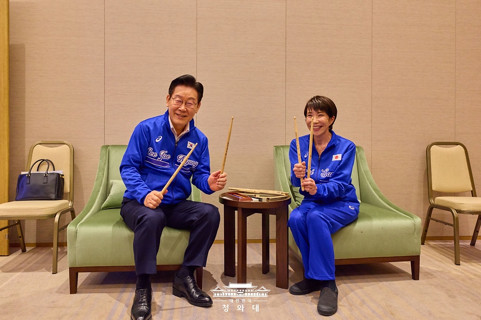 정상회담을 마친 이재명 대통령과 다카이치 사나에 일본 총리가 1월 13일 일본 나라현 환담장에서 드럼 합주 후 서로의 스틱에 서명한 뒤 교환하고 있다. 양 정상은 '케이팝 데몬 헌터스'의 주제가 '골든'과 BTS의 히트곡 '다이너마이트'에 맞춰 드럼을 함께 연주했다. 다카이치 총리는 학창 시절 헤비메탈 록밴드 드러머로 활동했다.