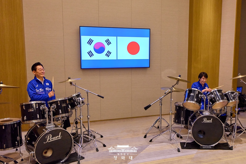 이재명 대통령과 다카이치 사나에 일본 총리가 1월 13일 일본 나라현에서 정상회담 후 환담장에서 드럼 합주를 하고 있다. 양 정상은 '케이팝 데몬 헌터스'의 주제가 '골든'과 BTS의 히트곡 '다이너마이트'에 맞춰 드럼을 함께 연주했다. 다카이치 총리는 학창 시절 헤비메탈 록밴드 드러머로 활동했다.