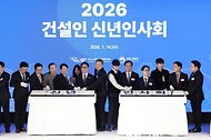 김민석 국무총리가 1월 14일 서울 강남구 건설회관에서 열린 2026 건설인 신년인사회에서 내빈들과 떡을 자르고 있다.