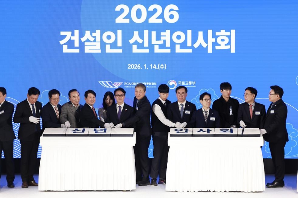 김민석 국무총리가 1월 14일 서울 강남구 건설회관에서 열린 2026 건설인 신년인사회에서 내빈들과 떡을 자르고 있다.