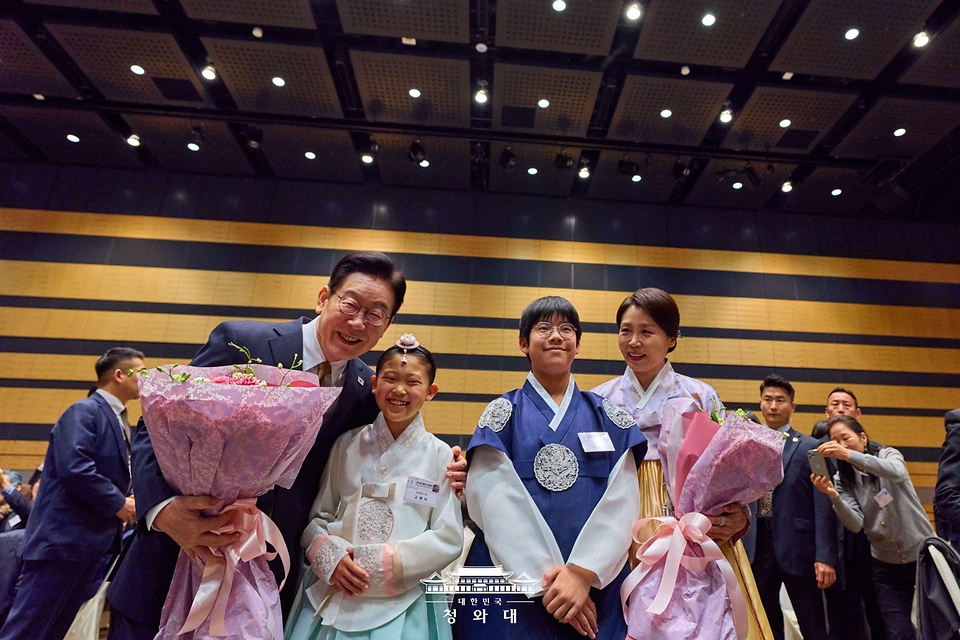 이재명 대통령과 김혜경 여사가 1월 14일 일본 나라현의 한 호텔에서 열린 간사이 동포 간담회에서 화동과 기념촬영을 하고 있다.