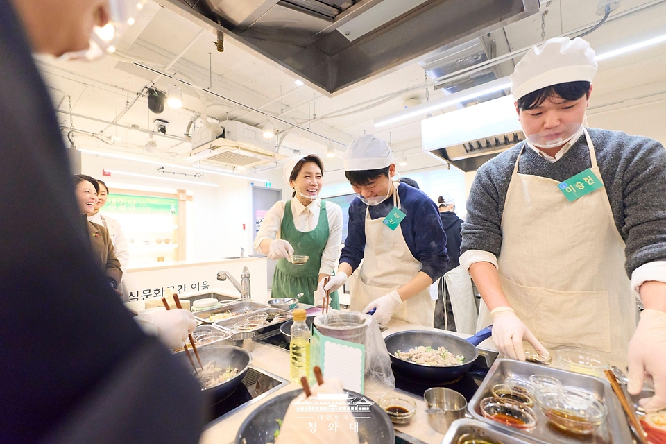 김혜경 여사가 1월 15일 서울 종로구 한식문화공간 이음에서 열린 자립준비청년들을 위한 생일상 차리기 행사에서 참석자들과 음식을 만들고 있다.