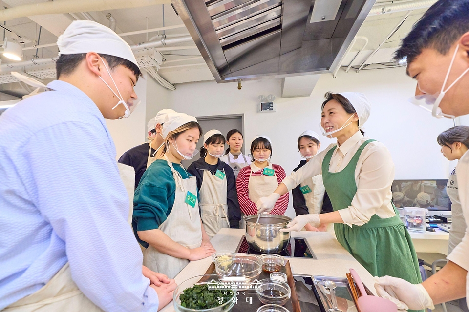 김혜경 여사가 1월 15일 서울 종로구 한식문화공간 이음에서 열린 자립준비청년들을 위한 생일상 차리기 행사에서 참석자들과 음식을 만들고 있다.