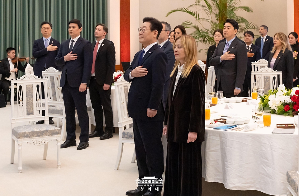 이재명 대통령이 1월 19일 청와대에서 열린 조르자 멜로니 이탈리아 총리와의 공식 오찬에서 국기에 경례하고 있다.