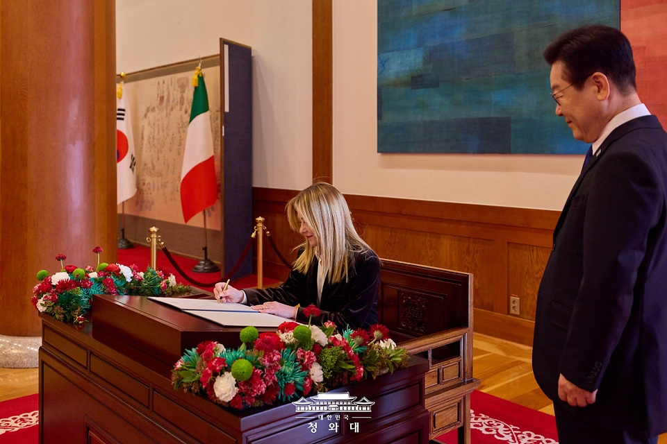 이재명 대통령이 1월 19일 청와대에서 한·이탈리아 정상회담에 앞서 조르자 멜로니 이탈리아 총리의 방명록 서명 모습을 바라보고 있다.