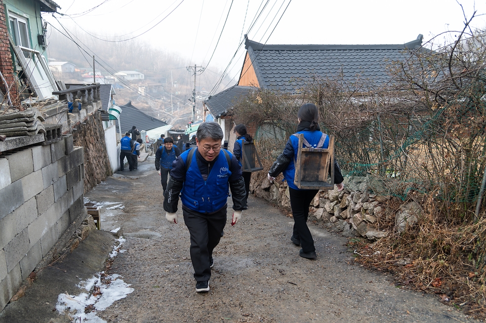 이정환 기상청 차장이 1월 16일 서울 서대문구 홍제동 개미마을을 찾아 한파 취약 가구에 연탄을 배달하고 있다.