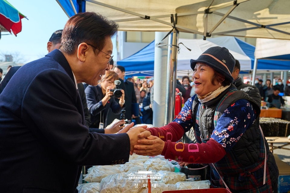 이재명 대통령이 1월 23일 울산 울주군 온양읍 남창옹기종기시장을 방문해 시장 상인과 인사를 하고 있다.