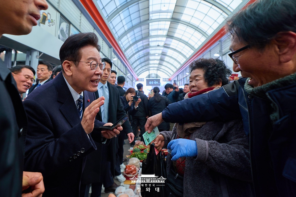 이재명 대통령이 1월 23일 울산 울주군 온양읍 남창옹기종기시장을 방문해 과일을 구매하고 있다.