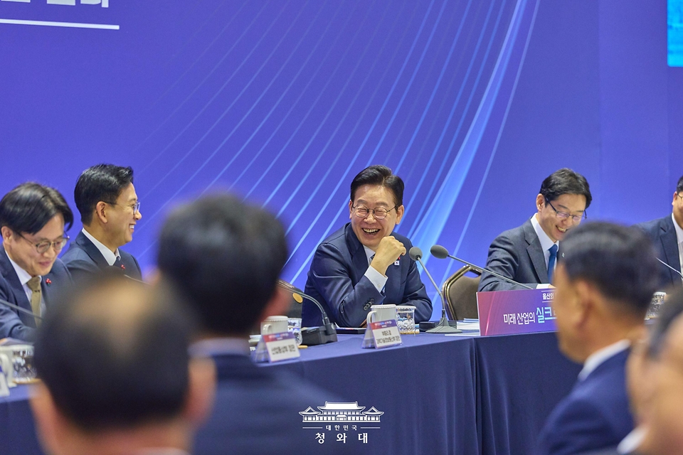 이재명 대통령이 1월 23일 울산전시컨벤션센터에서 열린 '울산의 마음을 듣다' 타운홀미팅 간담회에서 김정관 산업부 장관의 한미 협상 관련 발언에 박수를 받은 뒤 웃고 있다.