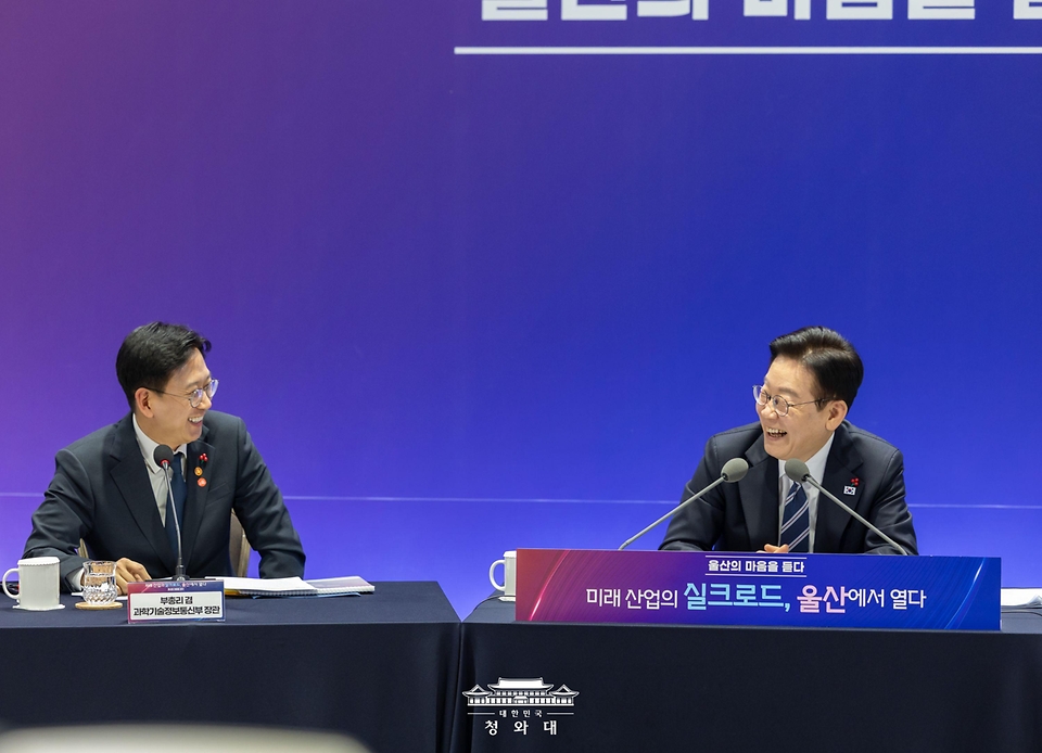 이재명 대통령이 1월 23일 울산전시컨벤션센터에서 열린 '울산의 마음을 듣다' 타운홀미팅 간담회에서 배경훈 과학기술정보통신부 장관과 울산에서 처음 만났던 인연을 이야기하며 웃고 있다.