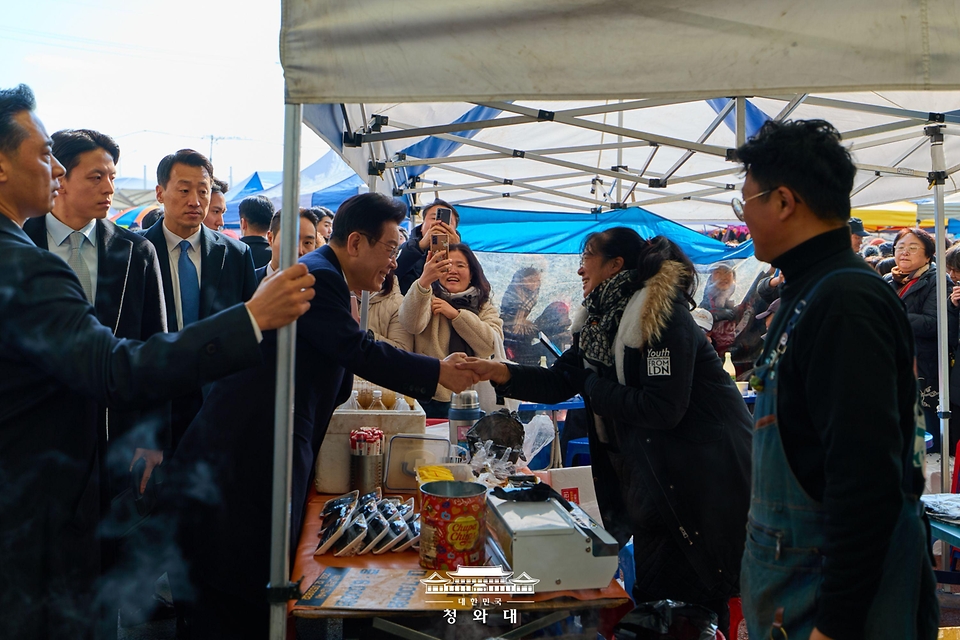 이재명 대통령이 1월 23일 울산 울주군 온양읍 남창옹기종기시장을 방문해 시장 상인과 인사를 하고 있다.