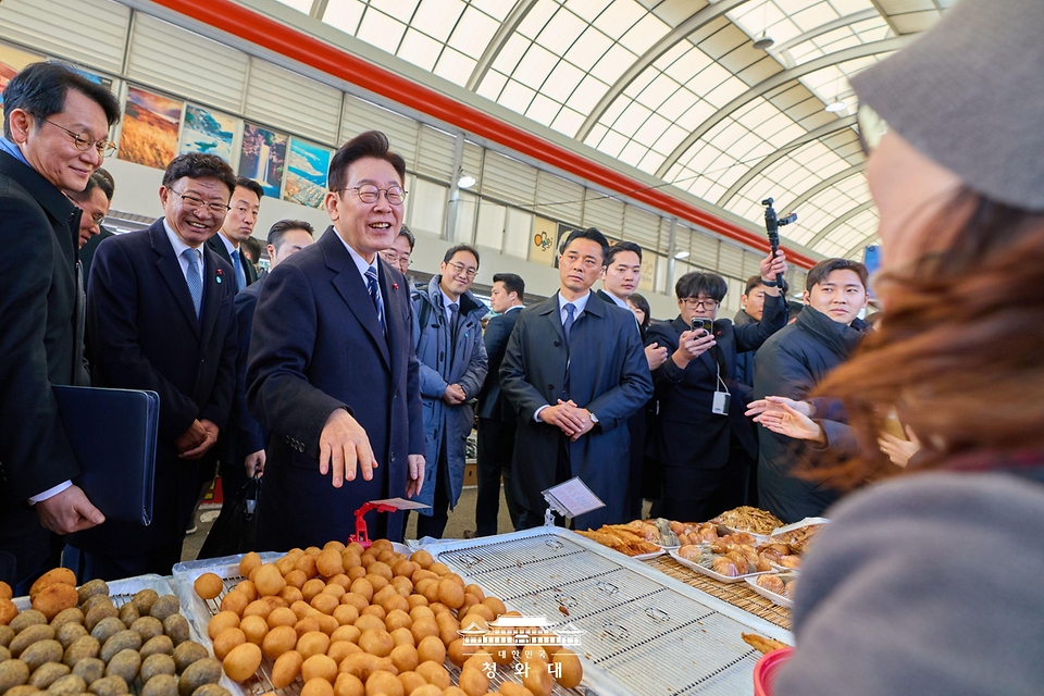 이재명 대통령이 1월 23일 울산 울주군 온양읍 남창옹기종기시장을 방문해 음식을 구매하고 있다.