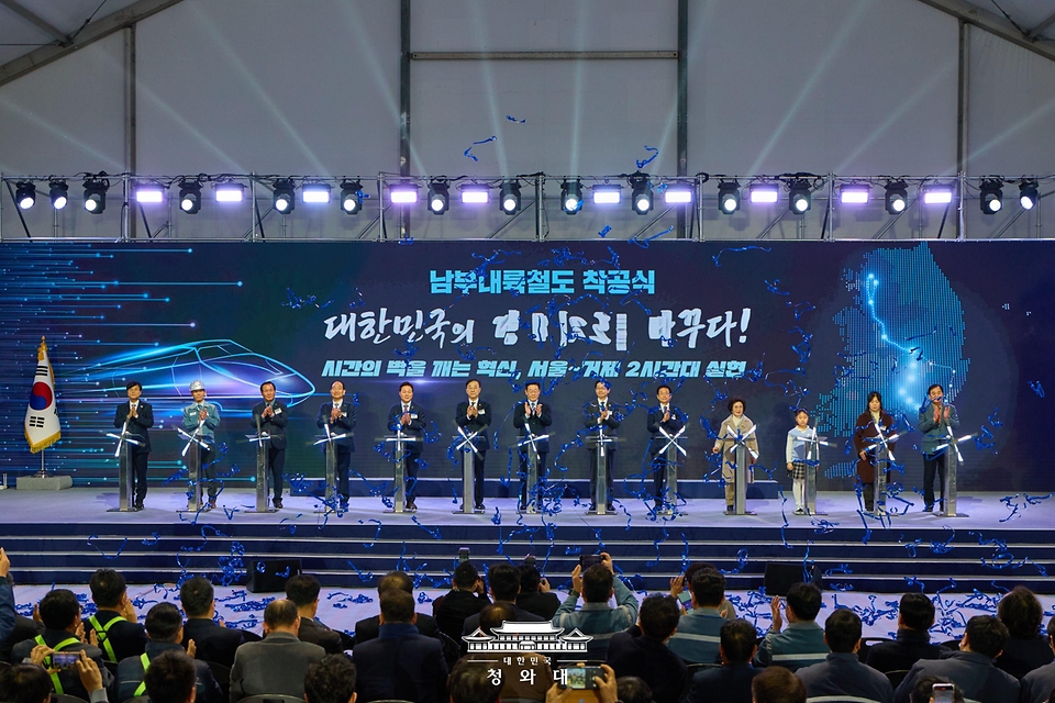 이재명 대통령이 2월 6일 경남 거제시 견내량 인근에서 열린 남부내륙철도 착공식에서 참석자들과 기념 세리머니를 하고 있다.