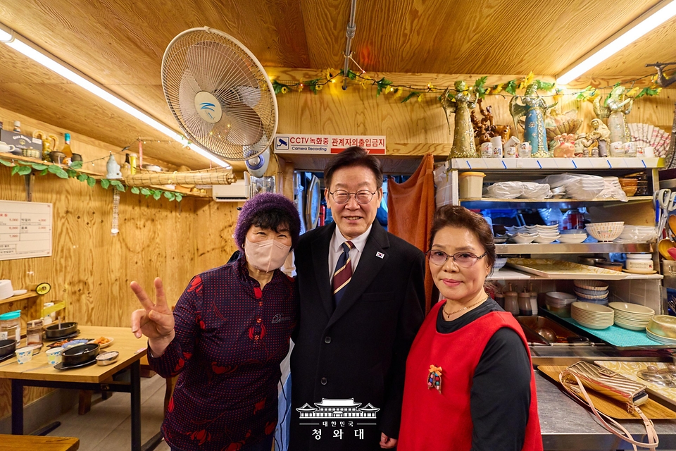 이재명 대통령이 2월 9일 서울 종로구 통인시장을 방문해 상인들과 기념촬영을 하고 있다.