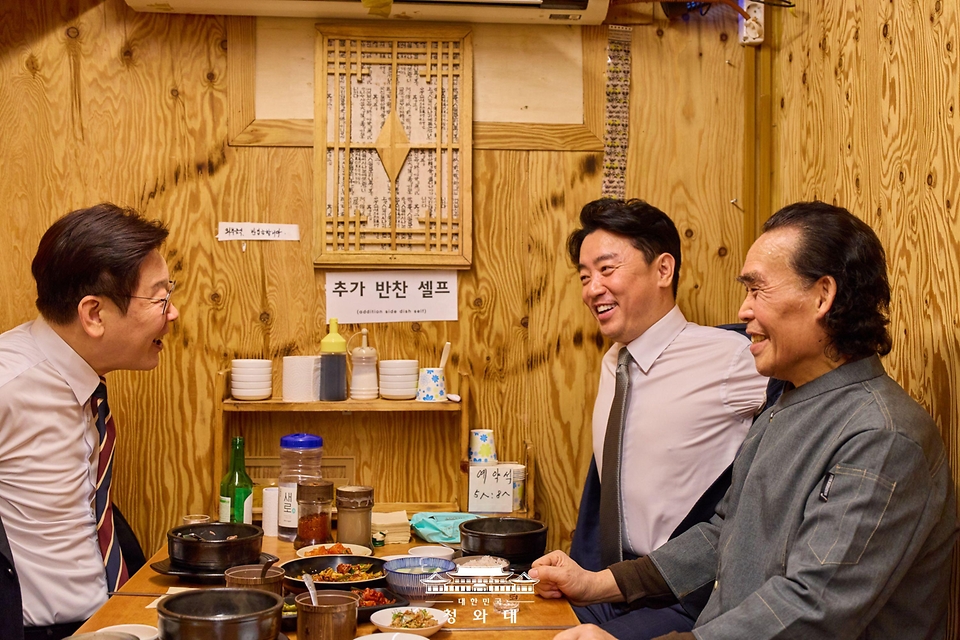 이재명 대통령이 2월 9일 서울 종로구 통인시장 한식당에서 강훈식 대통령비서실장과 저녁 식사를 하며 식당 주인과 대화하고 있다. 