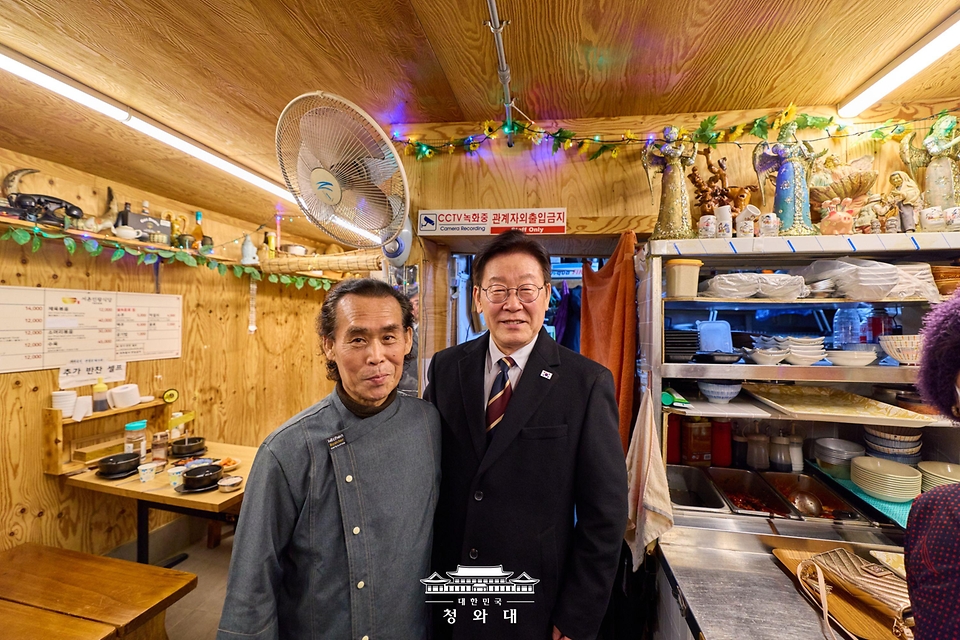 이재명 대통령이 2월 9일 서울 종로구 통인시장을 방문해 상인들과 기념촬영을 하고 있다.