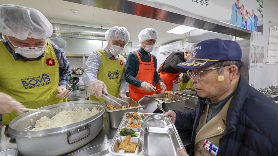 권오을 국가보훈부 장관이 2월 4일 오전 서울시 용산구 서울연탄은행에서 열린 민·관·군이 함께하는 설맞이 찾아가는 보훈 따뜻한 한 끼 봉사에 참석해 허기복 밥상공동체 연탄은행 대표 및 주요 내빈들과 함께 국가유공자들에게 배식 봉사를 하고 있다.