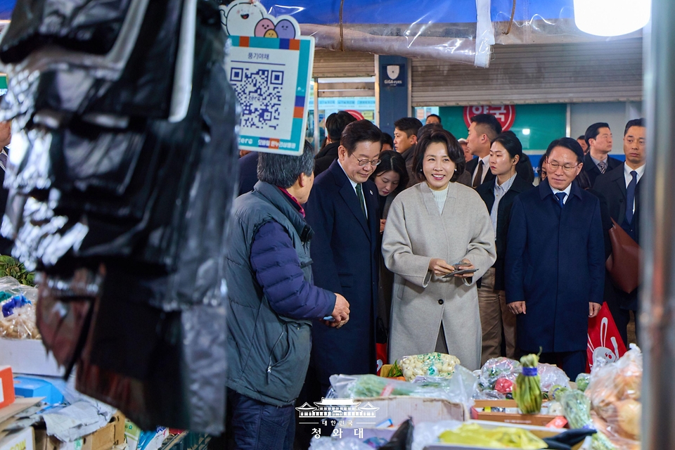 이재명 대통령과 김혜경 여사가 2월 11일 충북 충주시 무학시장을 방문해 상인들과 대화하고 있다.