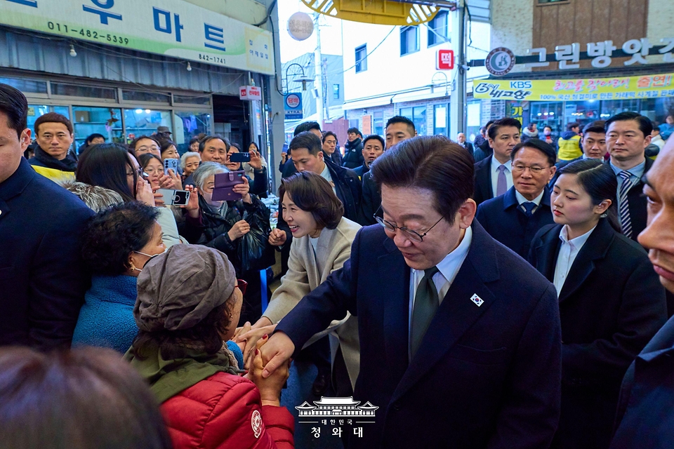 이재명 대통령과 김혜경 여사가 2월 11일 충북 충주시 무학시장을 방문해 상인과 인사하고 있다.