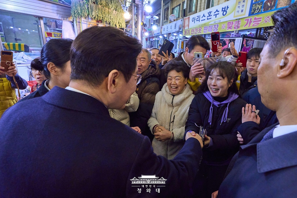 이재명 대통령과 김혜경 여사가 2월 11일 충북 충주시 무학시장을 방문해 상인과 인사하고 있다.