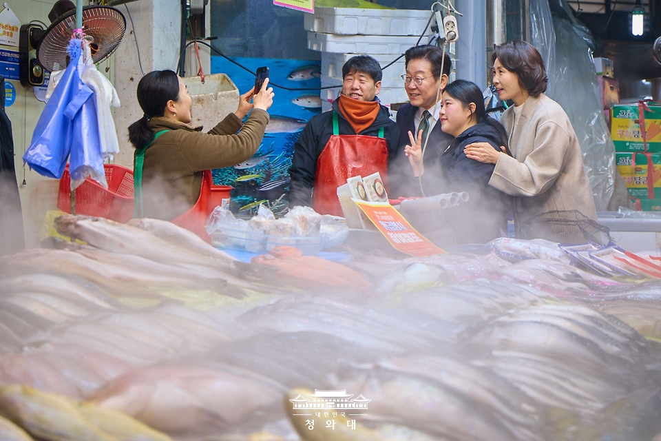 이재명 대통령과 김혜경 여사가 2월 11일 충북 충주시 무학시장을 방문해 상인들과 인사를 나누며 기념 사진을 찍고 있다. 