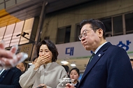 이재명 대통령과 김혜경 여사가 2월 11일 충북 충주시 무학시장을 방문해 한 상점에서 음식을 맛보고 있다.