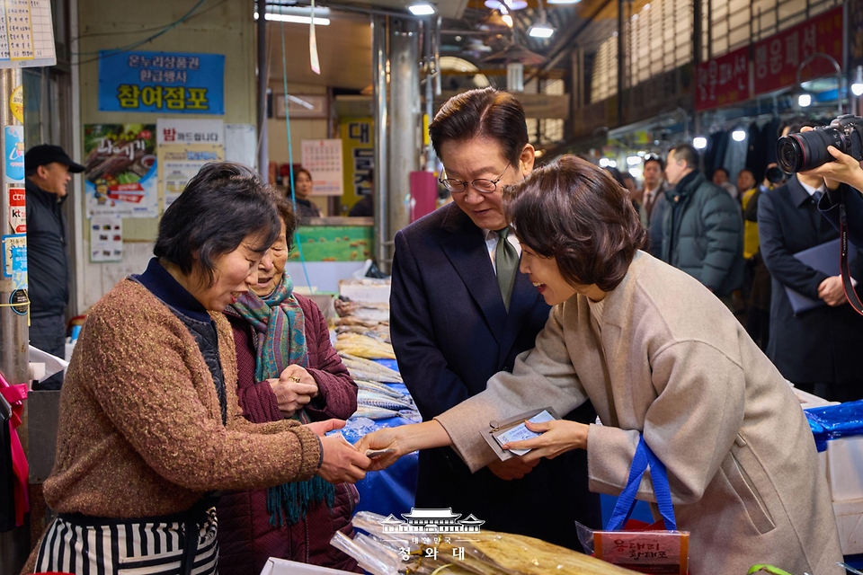 이재명 대통령과 김혜경 여사가 2월 11일 충북 충주시 무학시장을 방문해 상인과 인사하고 있다.