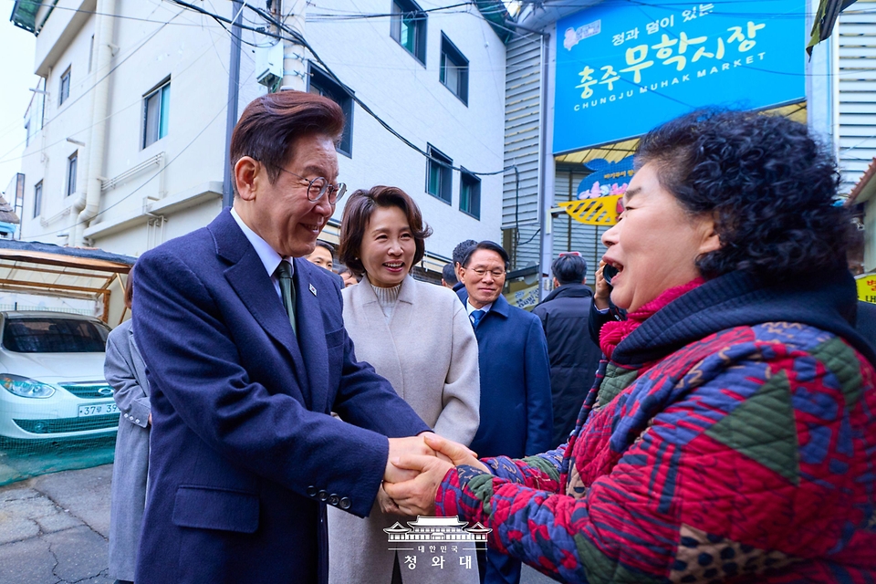 이재명 대통령과 김혜경 여사가 2월 11일 충북 충주시 무학시장을 방문해 상인과 인사하고 있다.