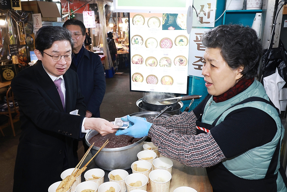 이억원 금융위원장이 2월 13일 서울 종로구 통인시장을 방문해 고기, 한과, 떡 등을 직접 구입하며, 시장 상인들로부터 최근 전통시장 설 경기와 애로사항을 청취 후 금융위가 추진하고 있는 상인들에 대한 민생금융지원 방안에 대해 이야기를 나누고 있다.
