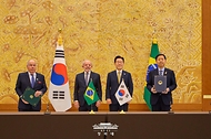 구윤철 부총리 재정부 장관과 페르난두 아다지 브라질 재무부장관이 2월 23일 청와대에서 이재명 대통령과 루이스 이나시우 룰라 다 시우바 브라질 대통령이 임석한 가운데 경제·금융대화 양해각서 문건을 교환한 뒤 기념촬영을 하고 있다.