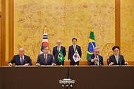 조현 외교부 장관과 김정관 산업통상부 장관, 마우루 비에이라 브라질 외교부 장관, 마르시우 엘리아스 호쟈 개발산업상공서비스부 차관이 2월 23일 청와대에서 이재명 대통령과 브라질 루이스 이나시우 룰라 다 시우바 대통령이 임석한 가운데 통상·생산 통합 협약을 체결하고 있다.