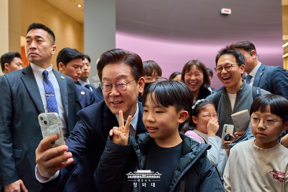 이재명 대통령이 2월 26일 서울 용산구 국립중앙박물관을 방문해 어린이와 셀카를 찍고 있다.