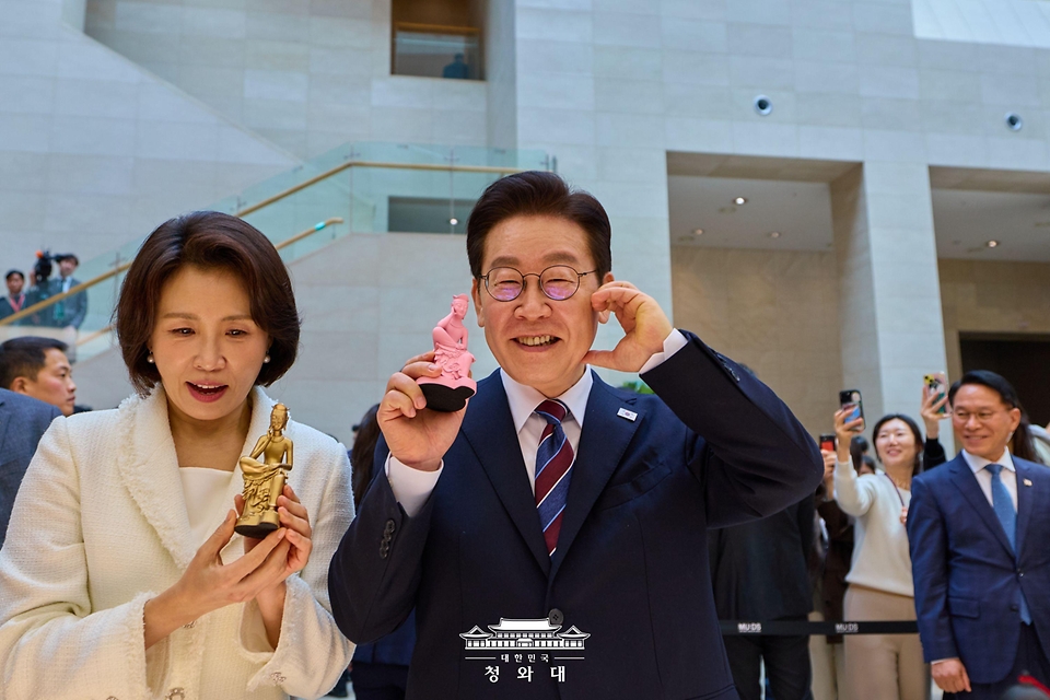 이재명 대통령과 김혜경 여사가 2월 26일 서울 용산구 국립중앙박물관에서 열린 광복 80주년 기념 특별전 '우리들의 이순신'을 관람한 뒤 기념품을 들고 기념촬영을 하고 있다.