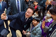 이재명 대통령이 2월 26일 서울 용산구 국립중앙박물관을 방문해 어린이와 셀카를 찍고 있다.